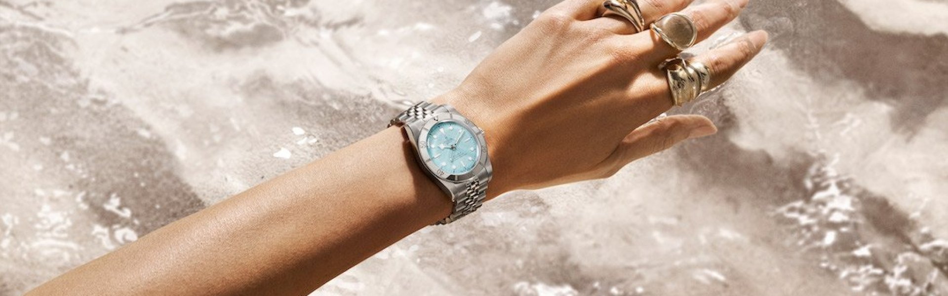 A watch might display the time, but this watch makes time melt away. Pack your bags, because we’re going somewhere idyllic

Wearing a TUDOR has the power to mentally transport you somewhere—and with the Black Bay 54 "Lagoon Blue", that somewhere is warm, the sun is shining, and waves of azure water are gently lapping against shell-dotted white sand beach. A watch can do more than tell time, it can shift your mindset. With a perfectly proportioned 37mm case and a "Lagoon Blue" dial plucked straight from paradise, this is the ideal complement to seasons full of sunsets, sand, and slowing down.

But it’s not only the case size that casts a spell on those who wear the newest Black Bay 54 iteration. It’s also in the magical combination of the sand-textured dial and mirror-polished bezel, not to mention the five-link bracelet that wraps perfectly around your wrist and feels like laying down in a well-worn hammock laced up between two palm trees right where the water meets the sand.

This is the watch that perfectly captures those dreamy vibes of summertime—forever.

The Black Bay line was conceived with the past in mind. Honouring the important designs that laid the foundation of TUDOR’s unique aesthetic is of the highest importance. While the Black Bay line has always incorporated signature elements of past TUDOR dive watches, the Black Bay 54 is perhaps the most true-to-form Black Bay to have been created thus far.

 

The Manufacture Calibre MT5400, with which the Black Bay 54 is equipped, displays hour, minute and second functions. It has the finish typical of TUDOR Manufacture Calibres: Its rotor in tungsten monobloc is openwork and satin-brushed with sand-blasted details, and its bridges and mainplate have alternate sand-blasted, polished surfaces and laser decorations.

Its build is designed to ensure robustness and precision. To do this, the variable inertia balance wheel is maintained by a sturdy traversing bridge with a two-point anchoring. This system, together with its non-magnetic silicon hairspring, enables the Manufacture Calibre MT5400 to function within a tolerance range of 6 seconds (-2/+4) tested on a fully assembled watch.

Another notable feature is that the power reserve of the Manufacture Calibre MT5400 is "weekend-proof"; that is to say, it has a 70-hour power reserve, which enables the wearer to take the watch off on a Friday evening and put it back on again on Monday morning without having to wind it. Even if you need a weekend away, your watch does not.

The Black Bay 54 is fitted with an entirely satin-brushed 5-link steel bracelet, complete with the TUDOR "T-fit" clasp equipped with a system for rapid length adjustment. Easy to use, requiring no tools and offering five positions, this practical system allows wearers to carry out a fine, instant adjustment of the total length of the bracelet along an adjustment window of 8mm. The clasp features ceramic ball bearings that ensure a smooth and secure closure in addition to adding a pleasing tactile element to the action of the clasp.  

 

The Black Bay line features dials inspired by the TUDOR divers’ watches produced during the 1950s. It borrows the characteristic angular hands known to collectors as “Snowflake” from models that appeared in the brand’s 1969 catalogue. Its unprotected crown and the characteristics of its case are reminiscent of the first generations of TUDOR divers' watches.

The Black Bay line is the result of the subtle blend of traditional aesthetics and contemporary watchmaking. Far from simply being an identical re-release of a classic, it brings together over seventy years of TUDOR dive watches, whilst at the same time being resolutely anchored in the present. It is neo-vintage in conception, yet its manufacturing techniques, reliability, robustness and the quality of its finish are consistent with today's more rigorous requirements.

 
